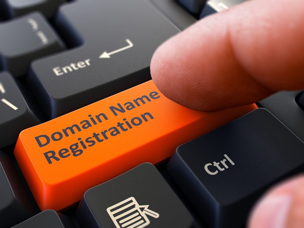 Finger Presses the Button Domain Name Registration on Black Keyboard - How to Register a Domain Name?